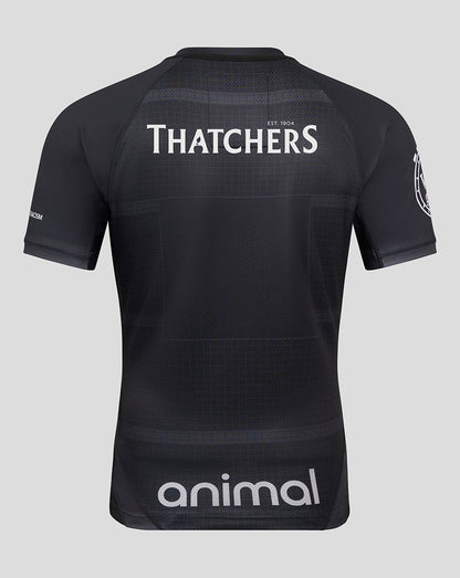 Back view of a dark patterned shirt with THATCHERS across the upper back and an animal sponsor at the lower back.