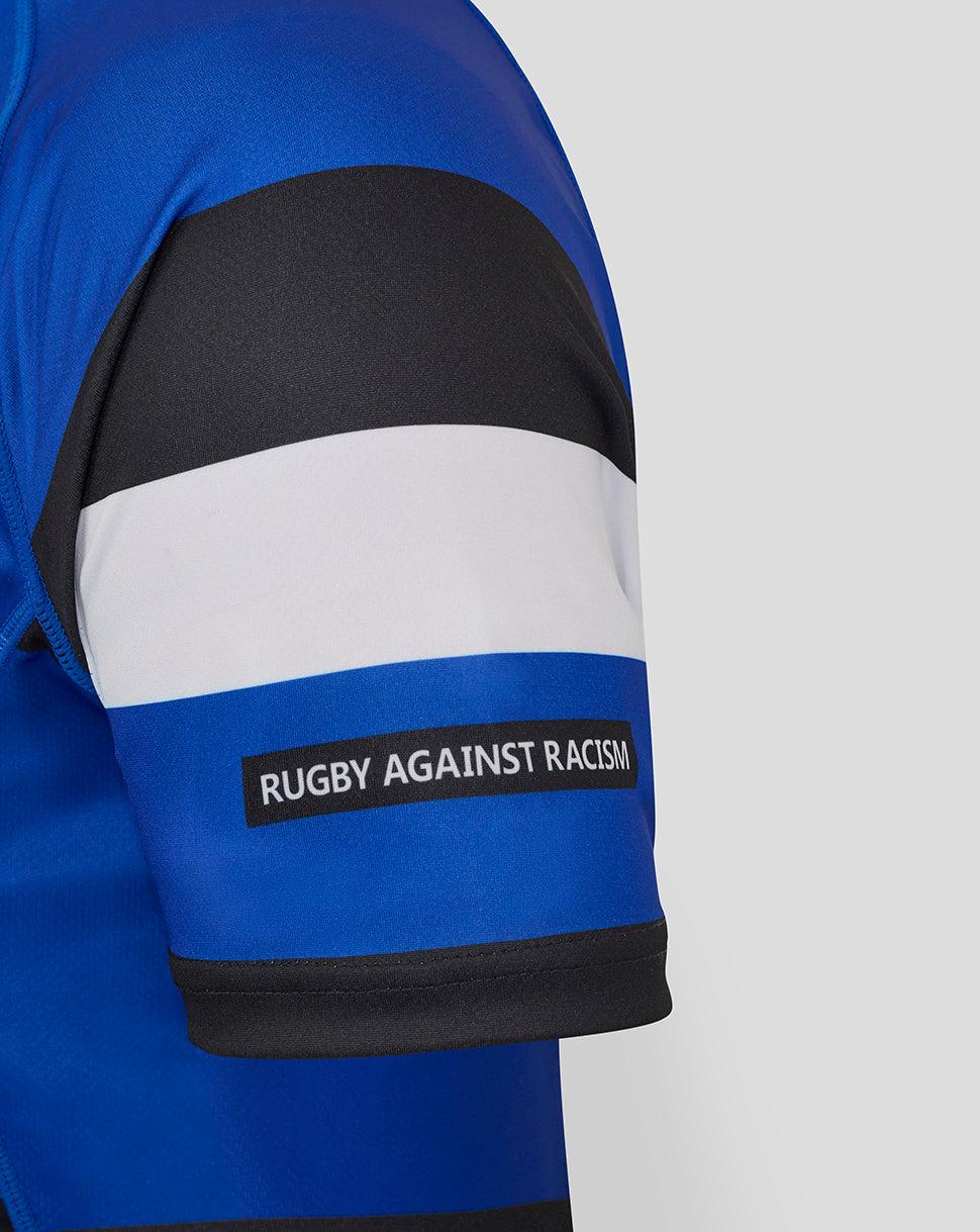 Bath Rugby Home Replica Shirt sleeve with blue armband and Rugby Against Racism badge on blue and white stripes.