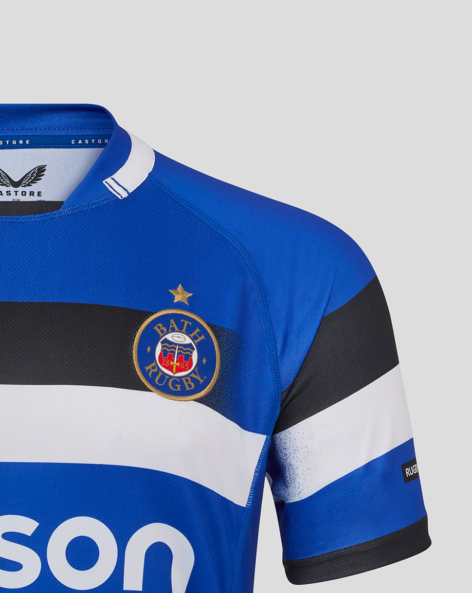 Close up of Bath Rugby Home Replica Shirt chest area showing club crest on blue jersey with bold stripes.