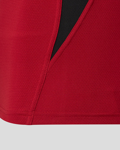 Close-up of lower side seam on the red Saracens training long sleeve tee with a black panel showing reinforced stitching.