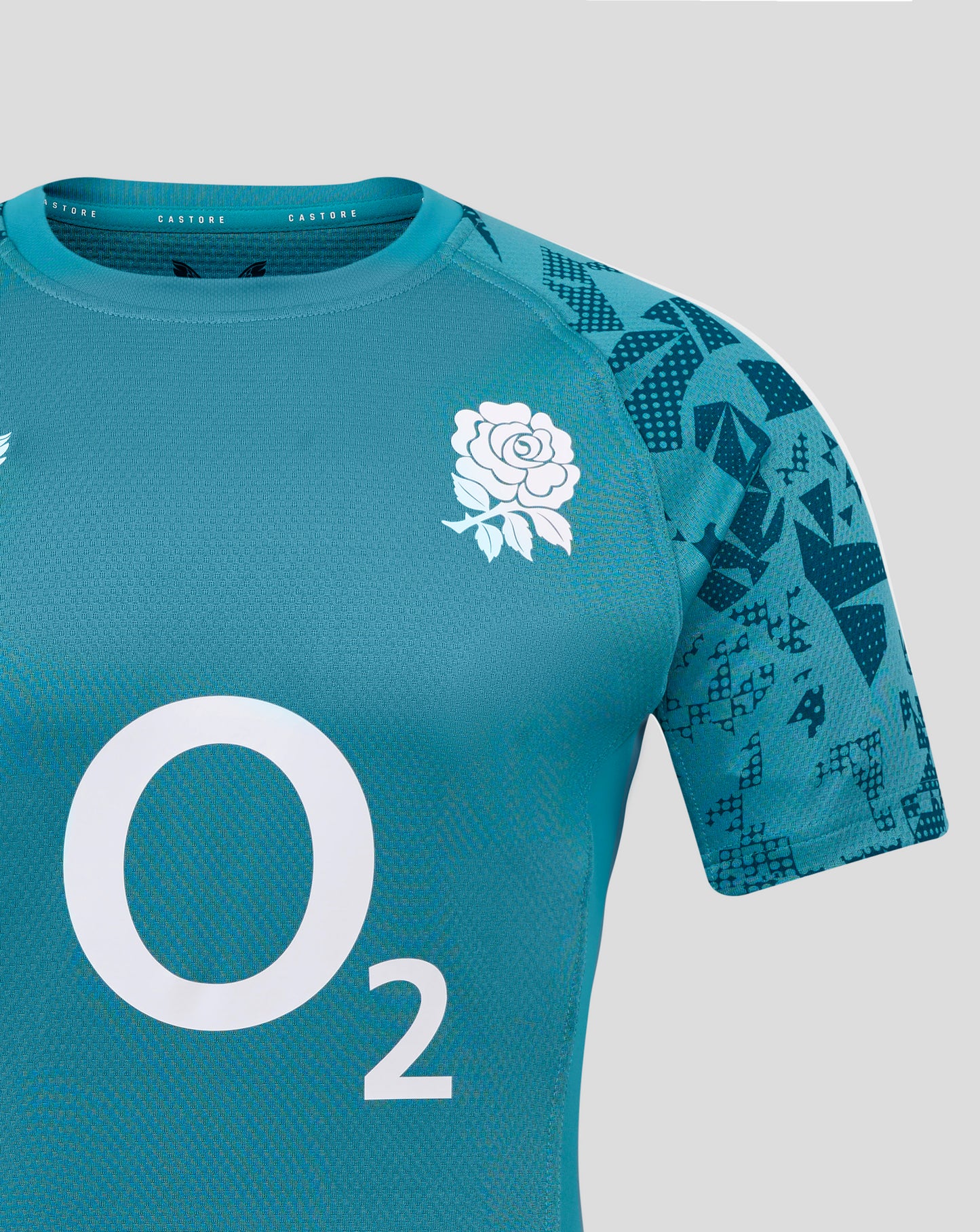 England rugby men's contact short sleeve jersey in teal with a white rose emblem on the chest and a geometric pattern on the sleeve, Castore branding at the neckline.
