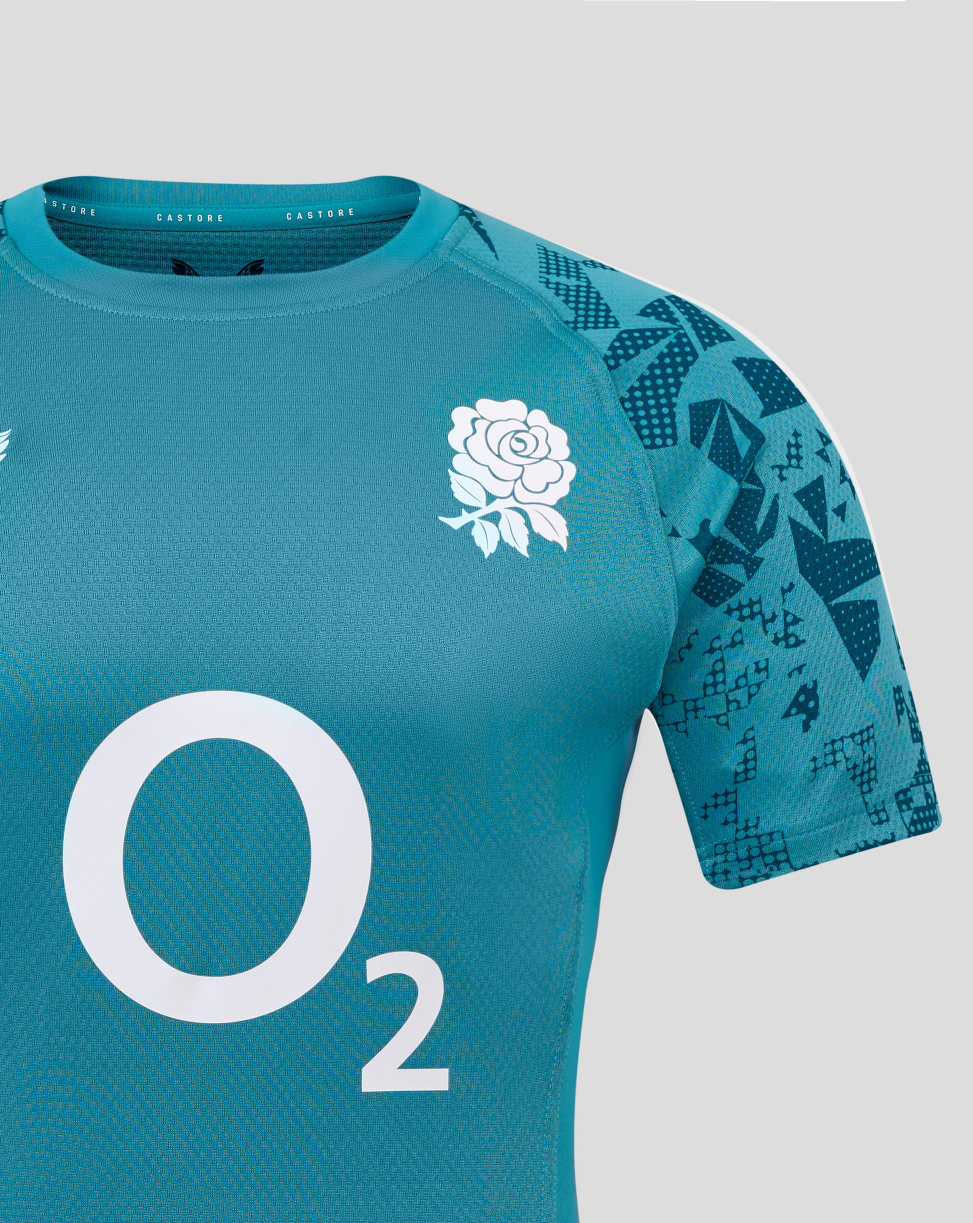 England rugby men's contact short sleeve jersey in teal with a white rose emblem on the chest and a geometric pattern on the sleeve, Castore branding at the neckline.