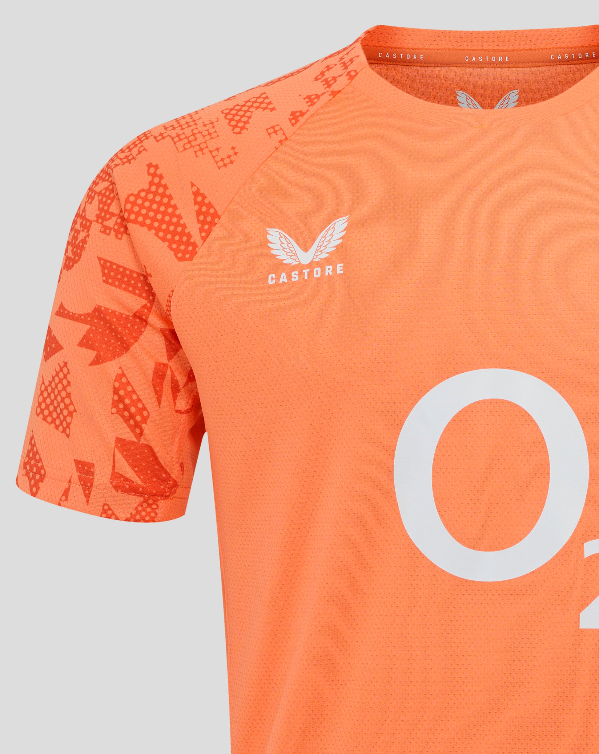 Close-up of the Melon England Rugby Performance short sleeve shirt, featuring abstract sleeve print, white rose crest on the left chest and Castore branding along the neckline.