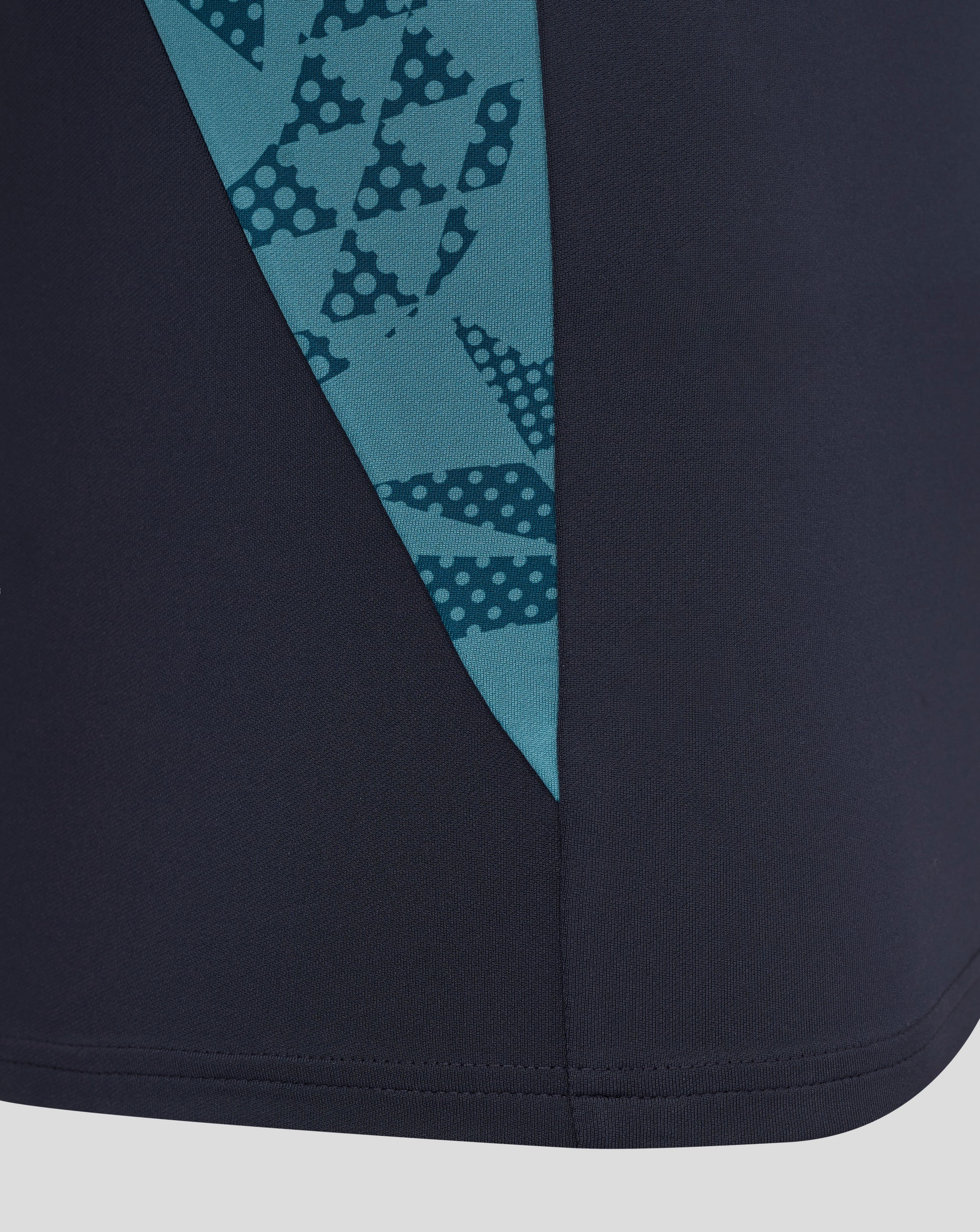 Close-up of navy performance midlayer fabric with a teal diagonal panel and dotted pattern from the England rugby top