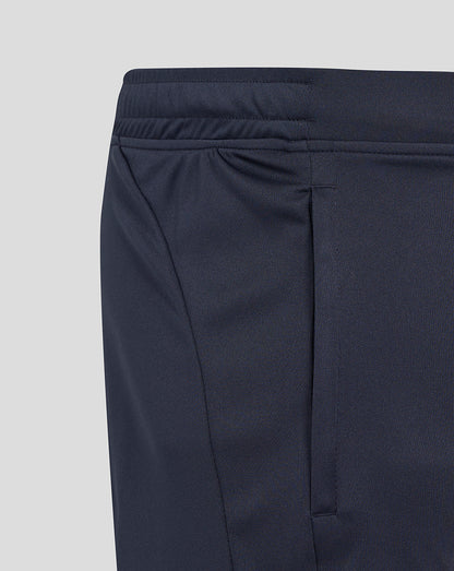 Detail of navy shorts featuring the elastic waistband and turquoise side panel with pocket seam.