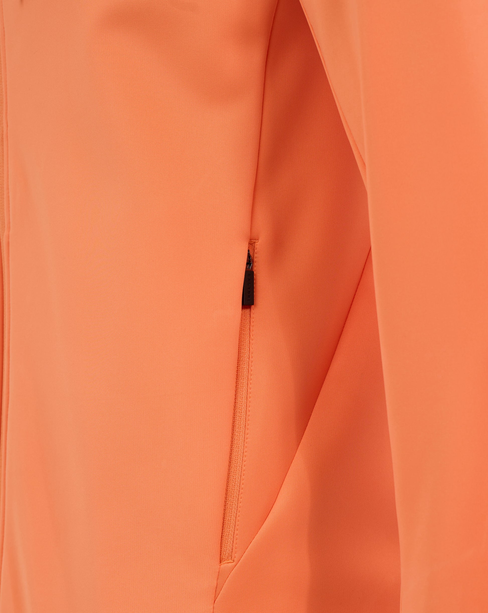 Close-up of orange Melon fabric with a visible zipper and seam on a men's England Rugby performance hoodie