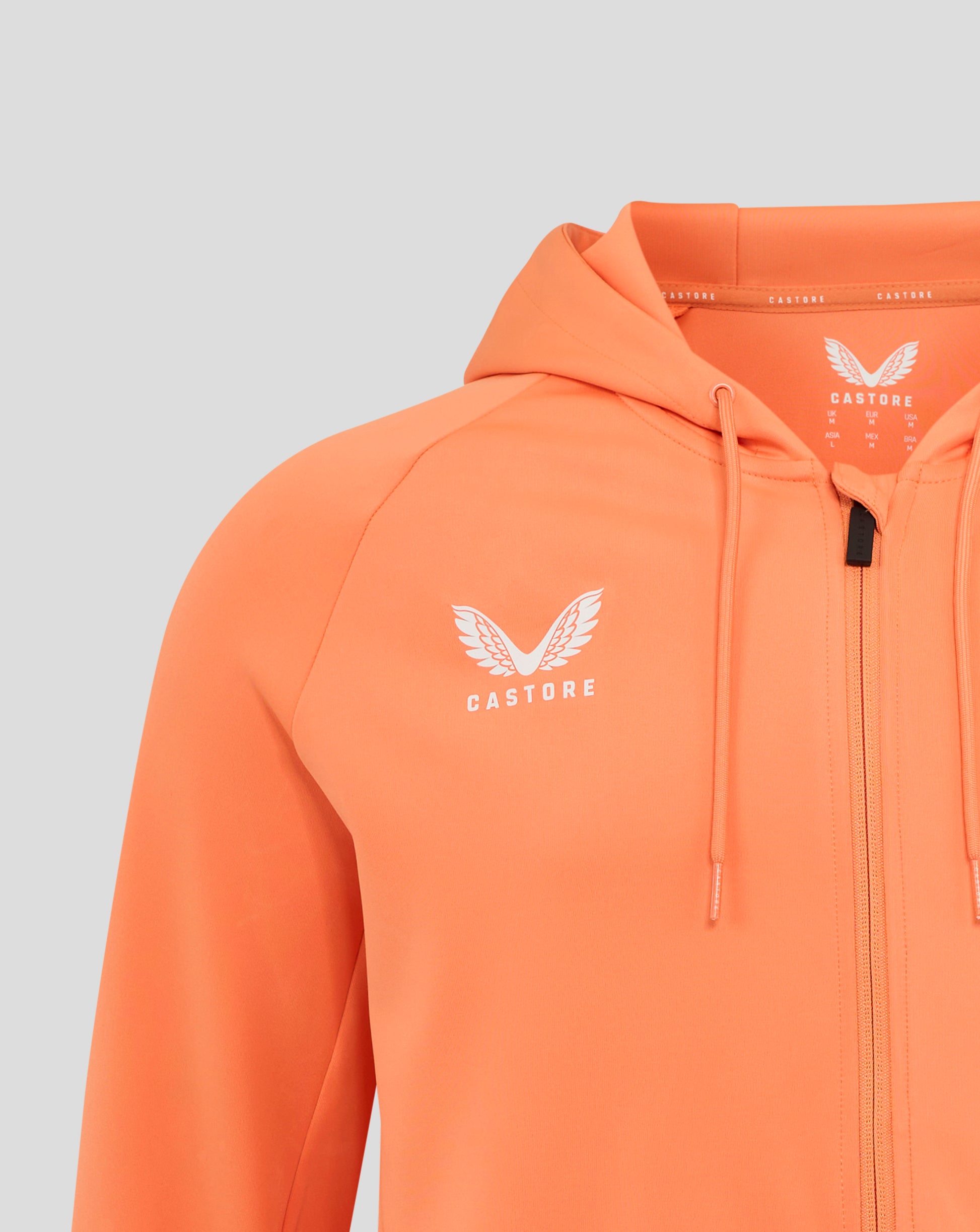 Front upper chest of melon hoodie showing white rose crest and Castore branding at neck tape