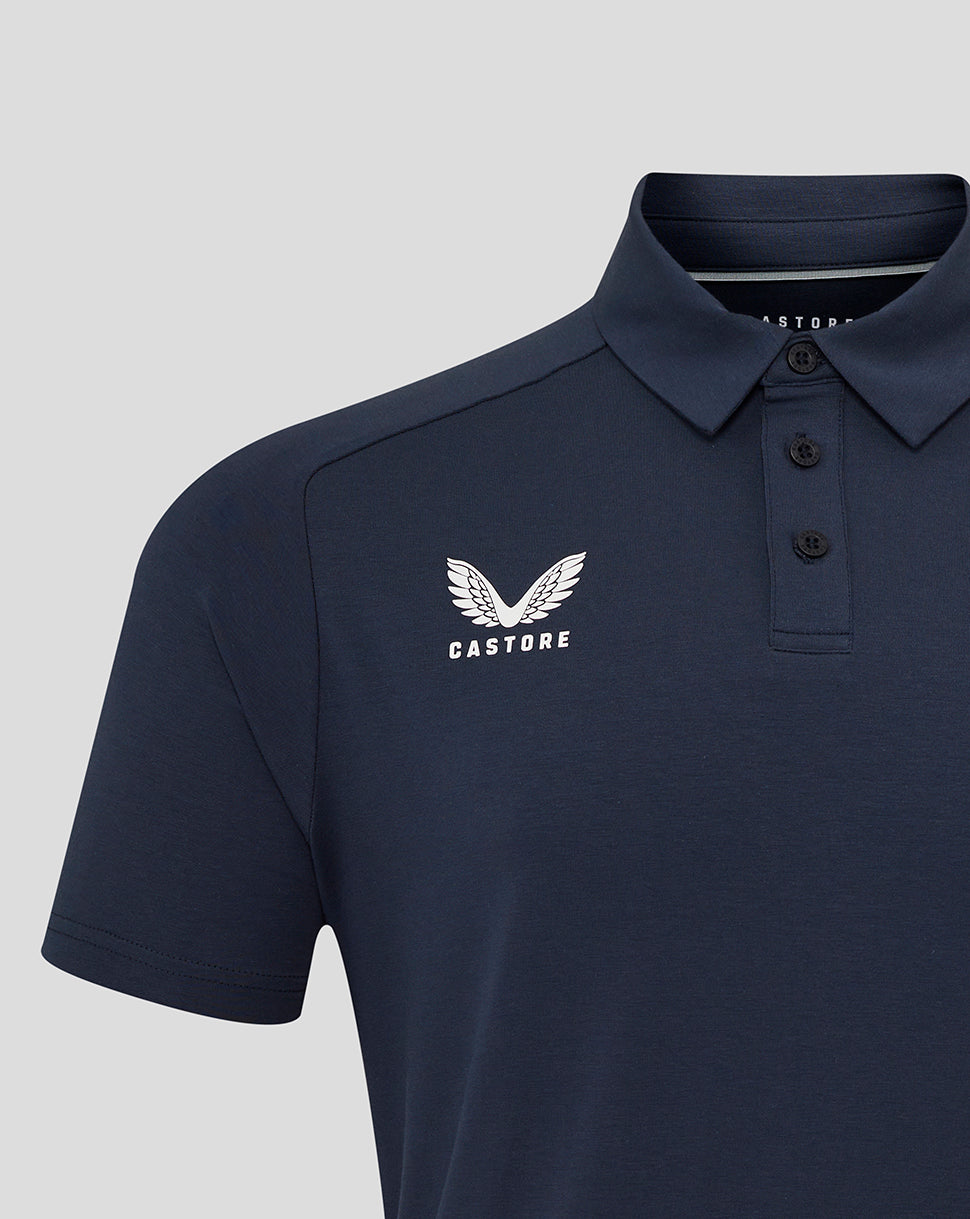 Close-up navy Travel Polo showing Castore logo on left chest and rose crest on right chest