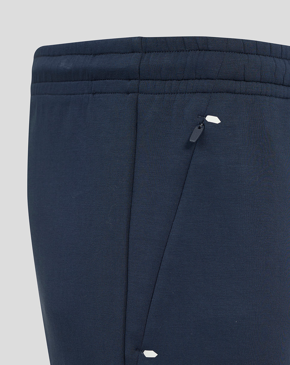 Close-up of navy shorts back with angled zip pocket and small white logo