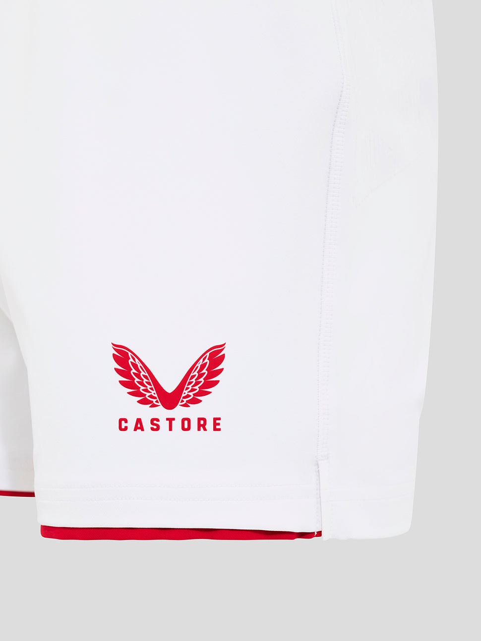 Side view of Brilliant White England Rugby Home Pro Shorts with blue O2 logo on the left thigh, red hem trim and Castore crest