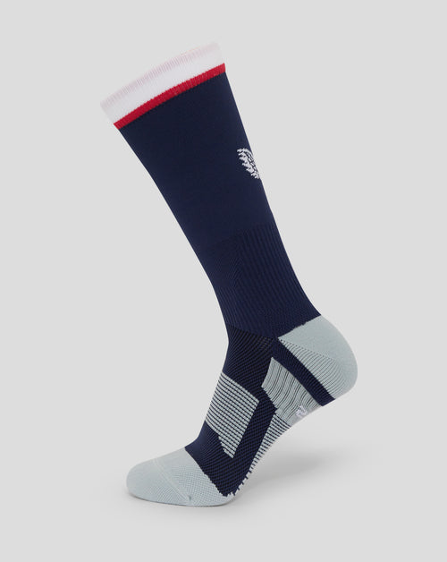 Mid calf navy sock with white cuff and red stripe and Castore logo on back leg