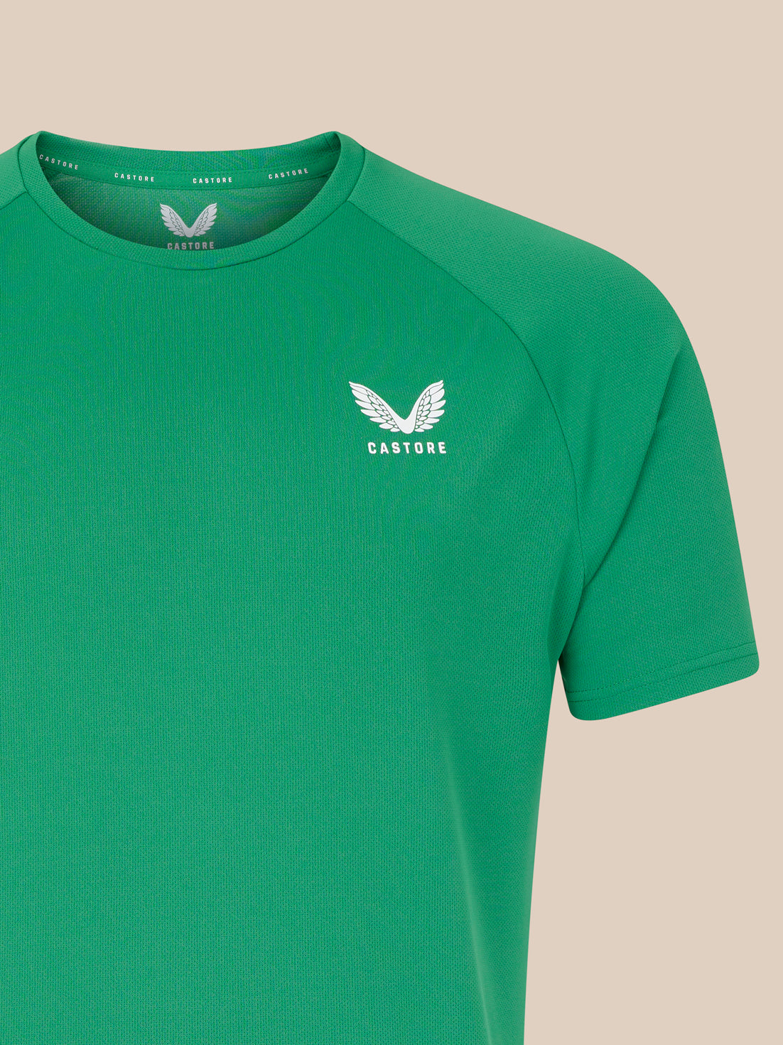 Green T shirt with white wing logo on left chest and visible shoulder seam