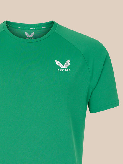 Green T shirt with white wing logo on left chest and visible shoulder seam