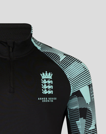 Chest view of black Ashes Pro Quarter Zip top showing crest and Ashes Series 2025/26 text with teal patterned sleeve.