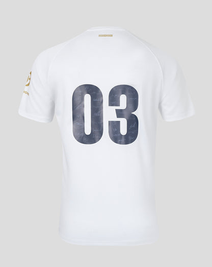 Back view of a white replica jersey with large 03 numbers filled with signatures and a small gold Champions label at the neckline.