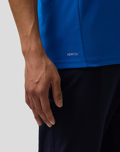Detail of blue BWT Alpine polo showing AERTEK moisture wicking label at the hem.