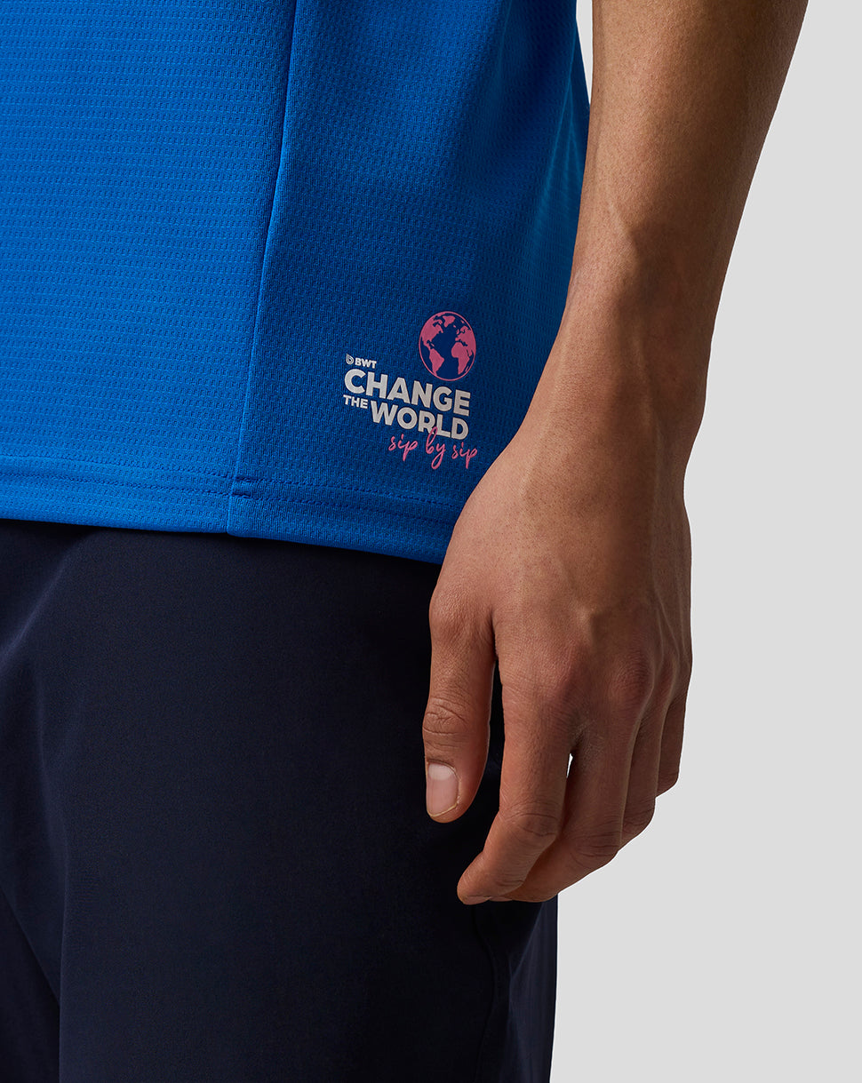 Back view of blue BWT Alpine polo with Change the World sip by sip logo near the hem.