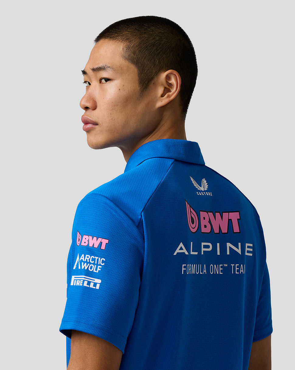Back view of model wearing blue BWT Alpine polo with sponsor logos on back and sleeve.