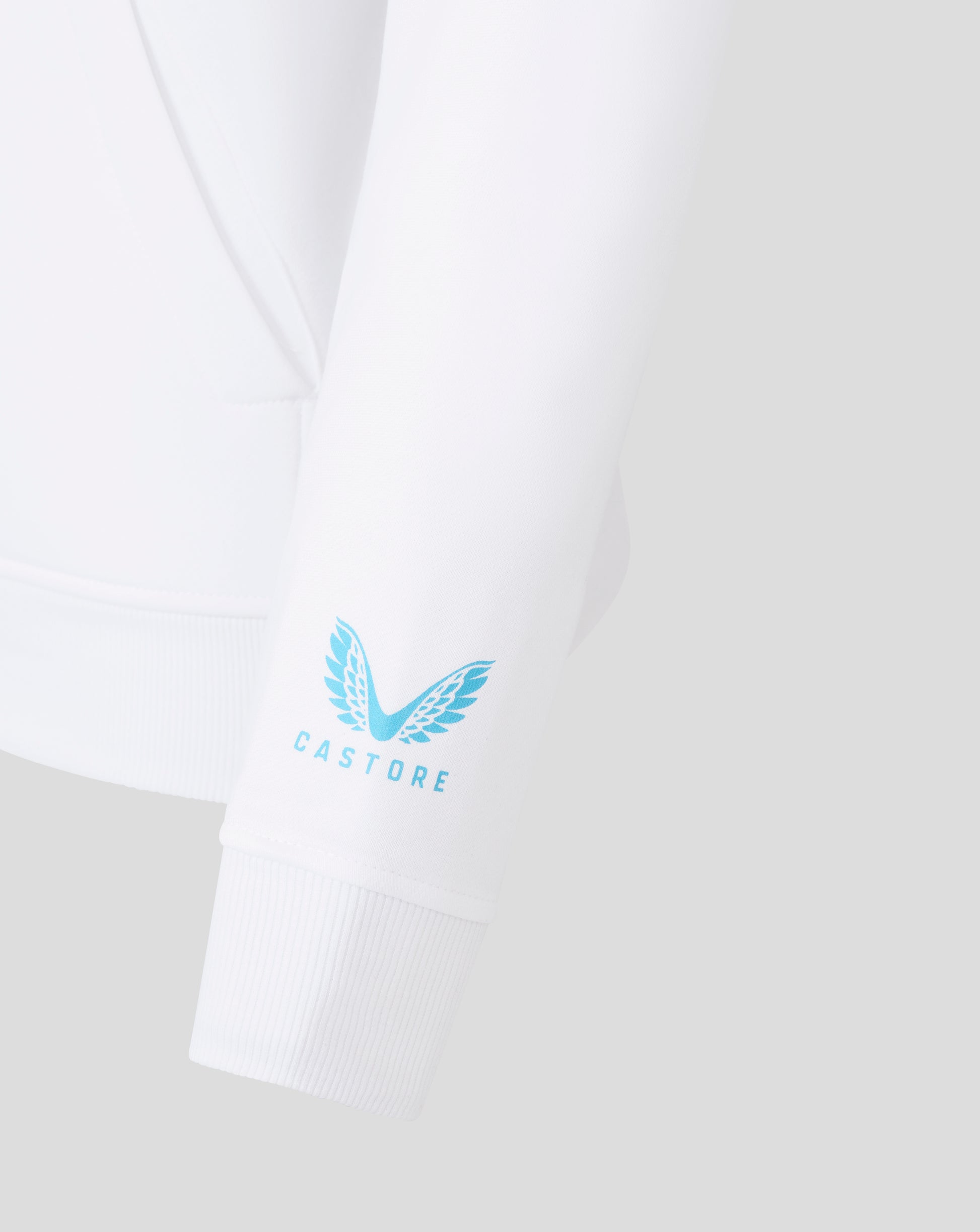 Close-up of a white hoodie sleeve with a light blue winged emblem and CASTORE text at the cuff