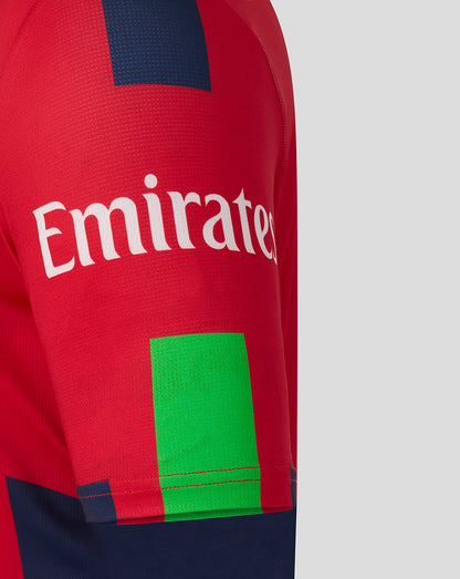 Red jersey sleeve with Emirates branding across the fabric and a neon green patch at the hem.