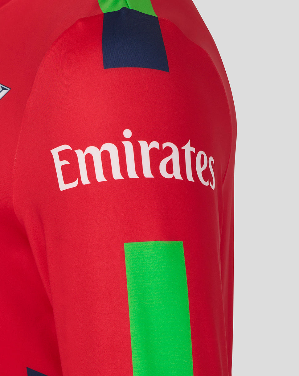 Close-up of the Lancashire Lightning crest on a red T20 sweatshirt with Emirates logo and neon green geometric panels.