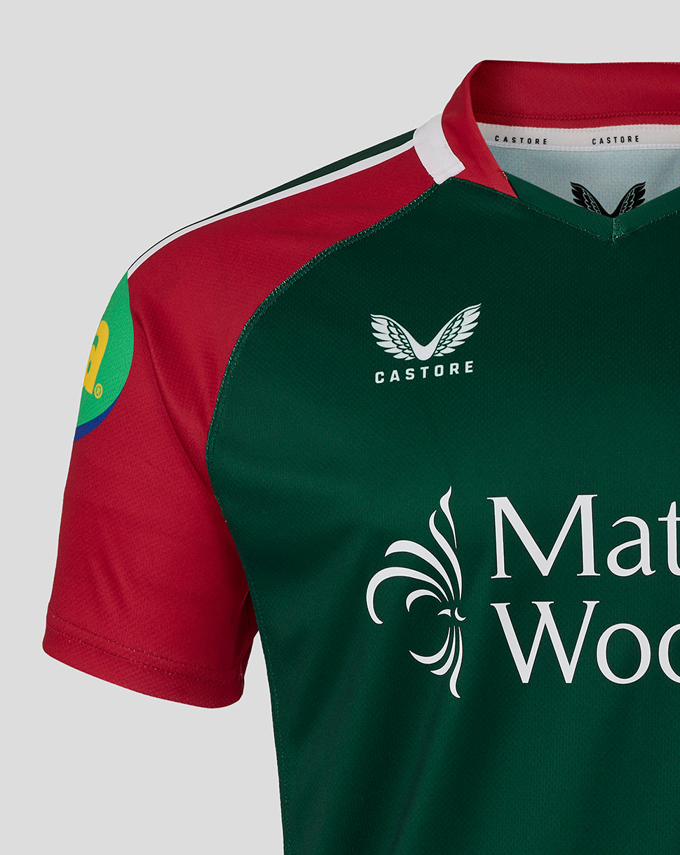 Close up of the chest area on the Leicester Tigers junior 25/26 replica home shirt showing green body red sleeves and sponsor logos.