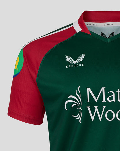 Close up of the chest area on the Leicester Tigers junior 25/26 replica home shirt showing green body red sleeves and sponsor logos.