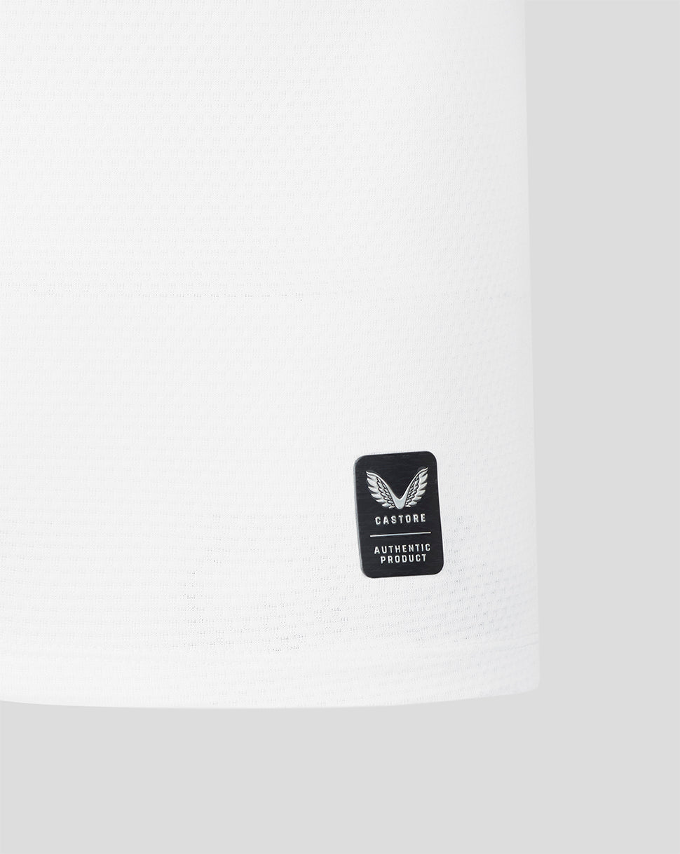 Close up of white jersey fabric featuring a black Castore authentic product badge.