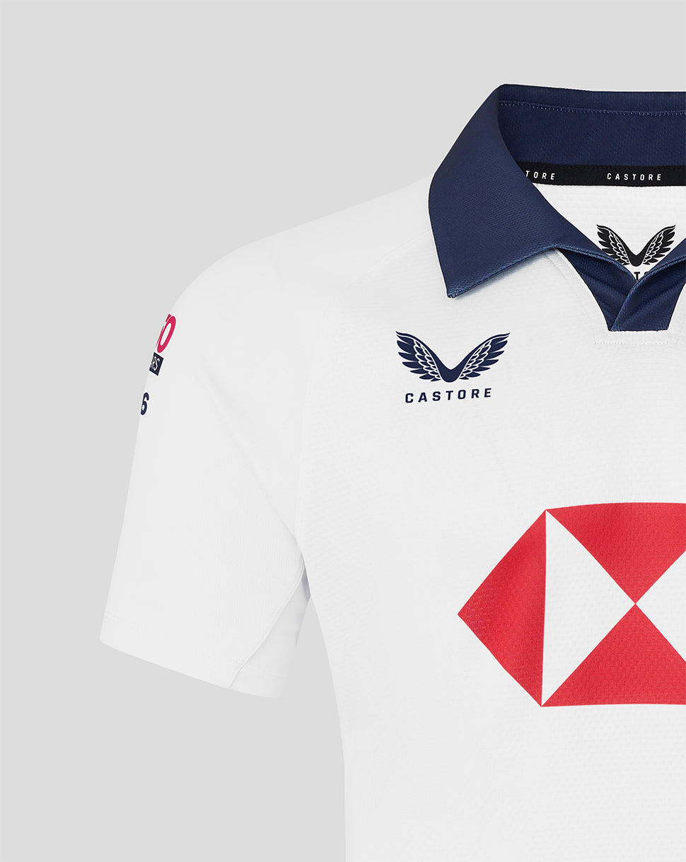 White jersey with navy collar and a large red diamond sponsor logo on the chest.