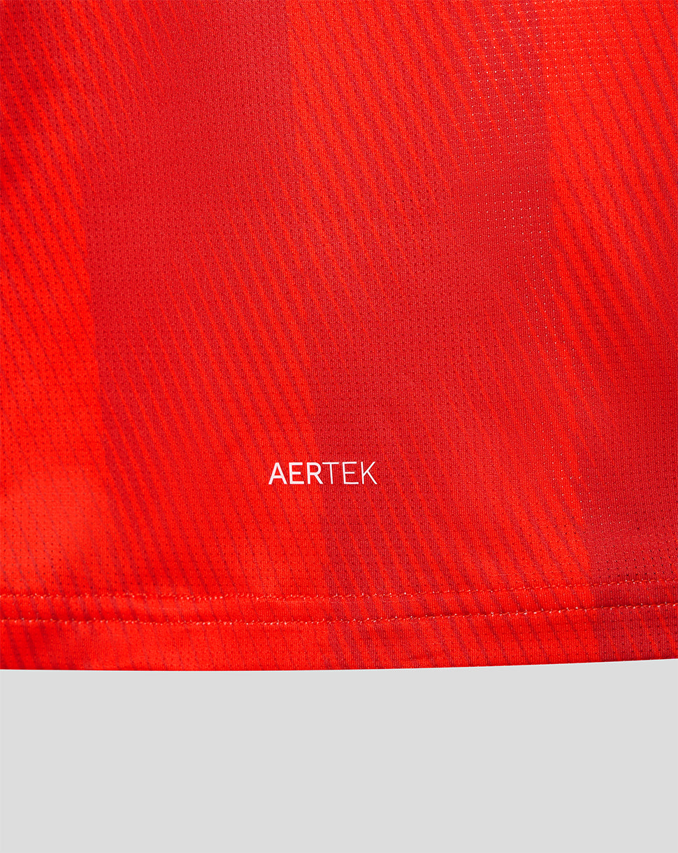 Close-up of red jersey fabric with AERTEK branding near the hem.