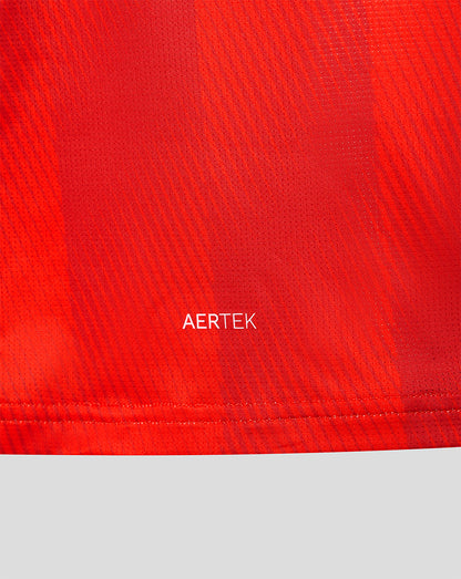 Close-up of red jersey fabric with AERTEK branding near the hem.