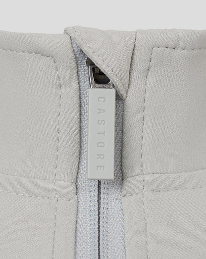 Close-up of light grey track jacket zipper with a CASTORE branded pull.