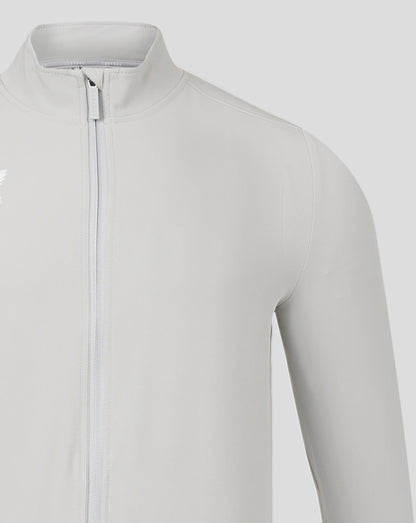 Close-up of collar and front zip on light gray Mens Track Jacket High Rise with Castore branding.