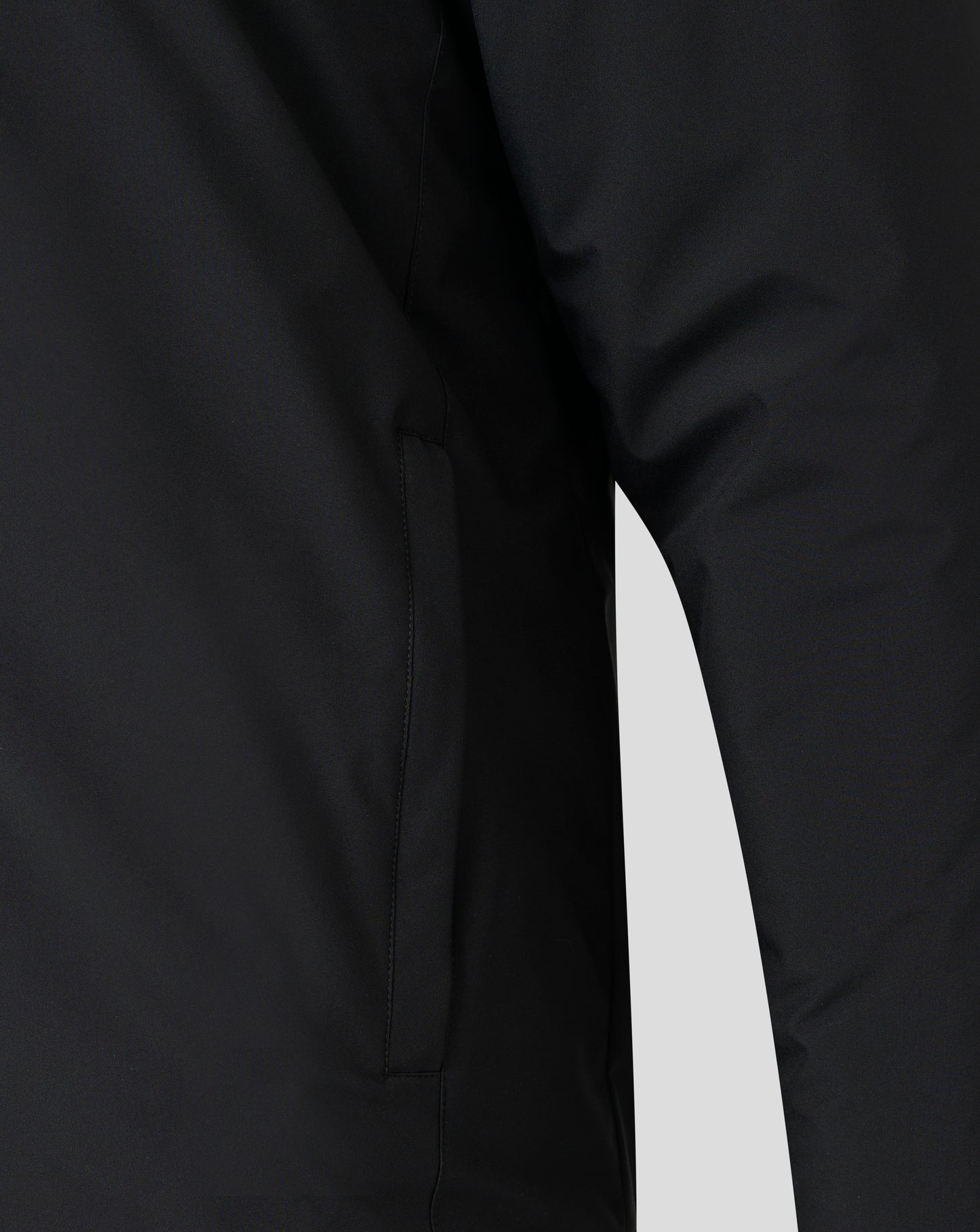 Close-up of black bench jacket fabric showing a front seam and folded edge