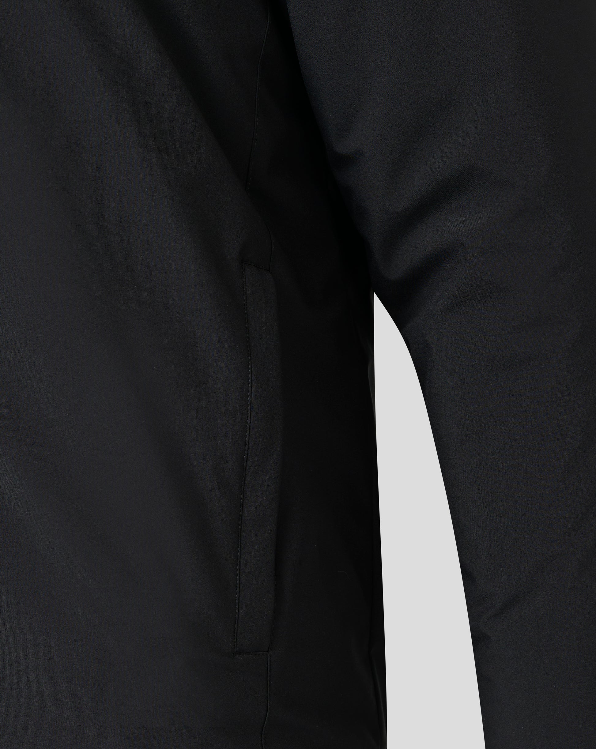 Close-up of black bench jacket fabric showing a front seam and folded edge
