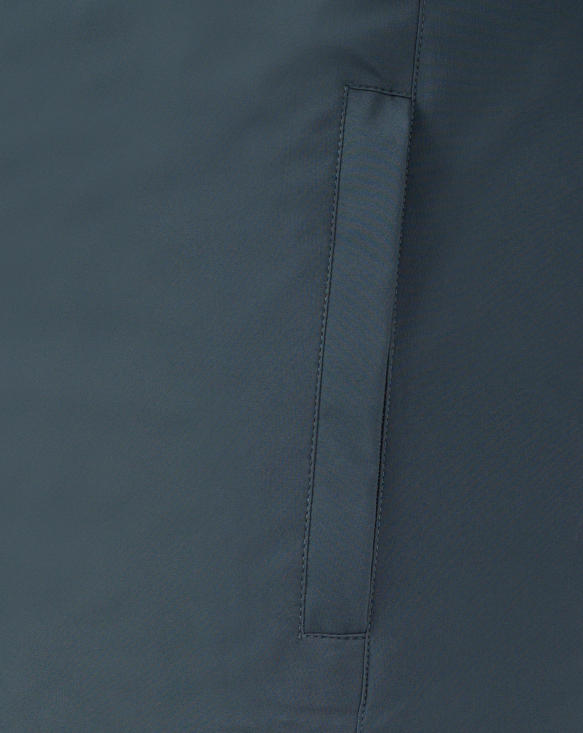 Close up of dark slate bench jacket fabric showing a vertical seam and strap detail.