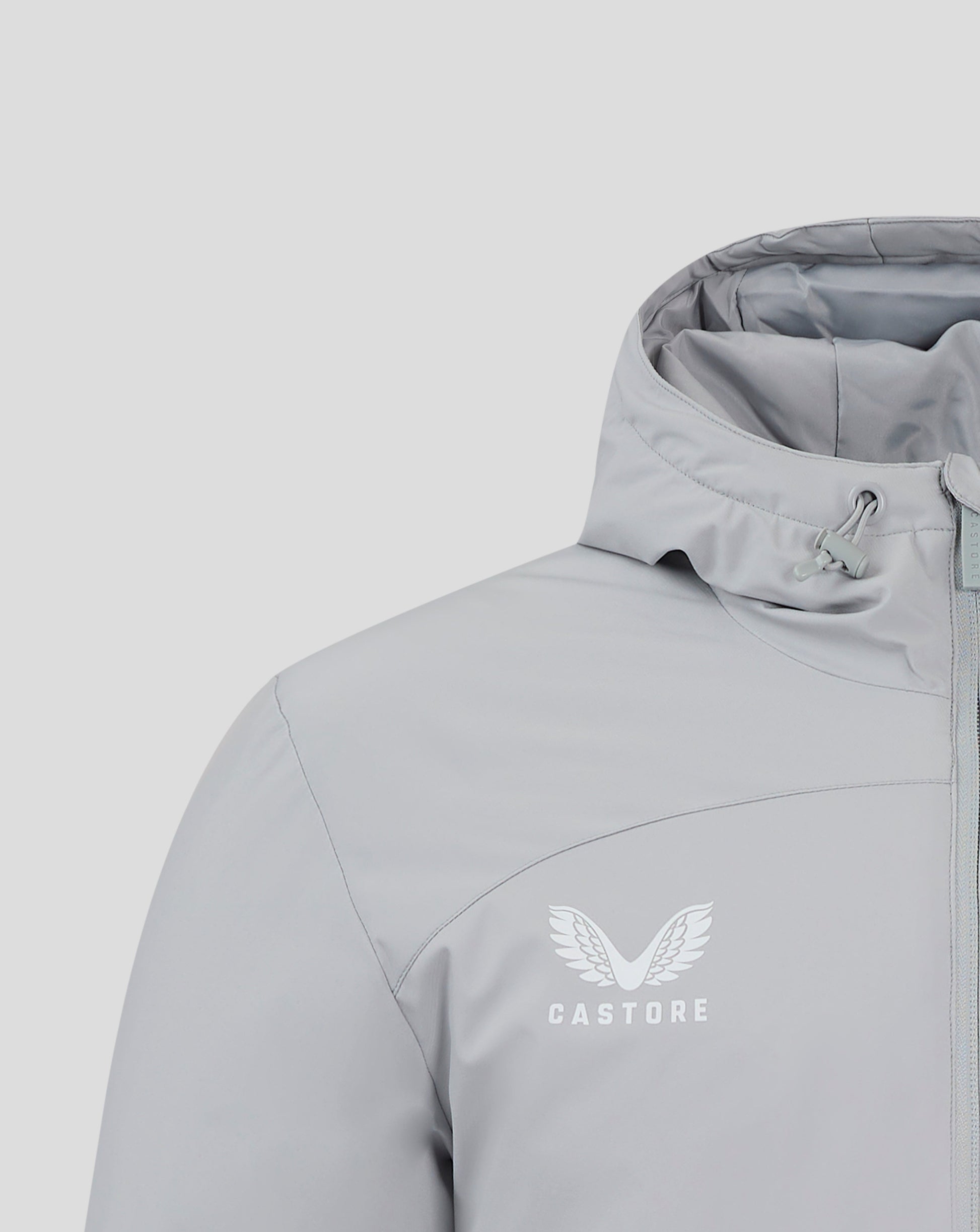 Close up of chest area with winged Castore logo on light gray Bench Jacket