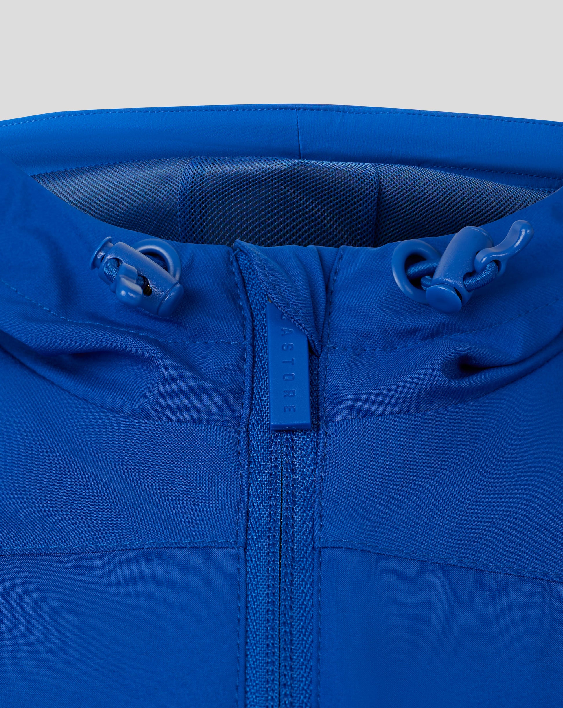 Blue rain jacket close-up at the collar with a centered zipper, hood drawcords and mesh lining