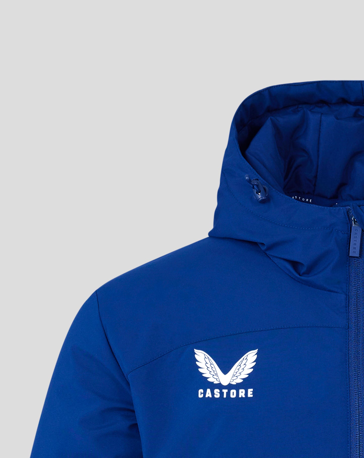 Close up of hood interior on blue bench jacket with visible Castore branding on zipper tape