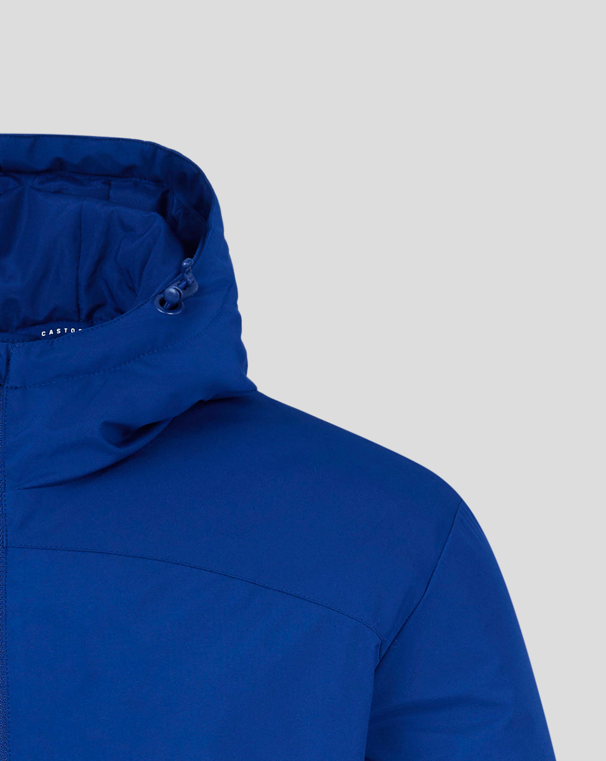 Close up of blue padded hooded jacket showing hood edge, drawcord toggle, and Castore logo