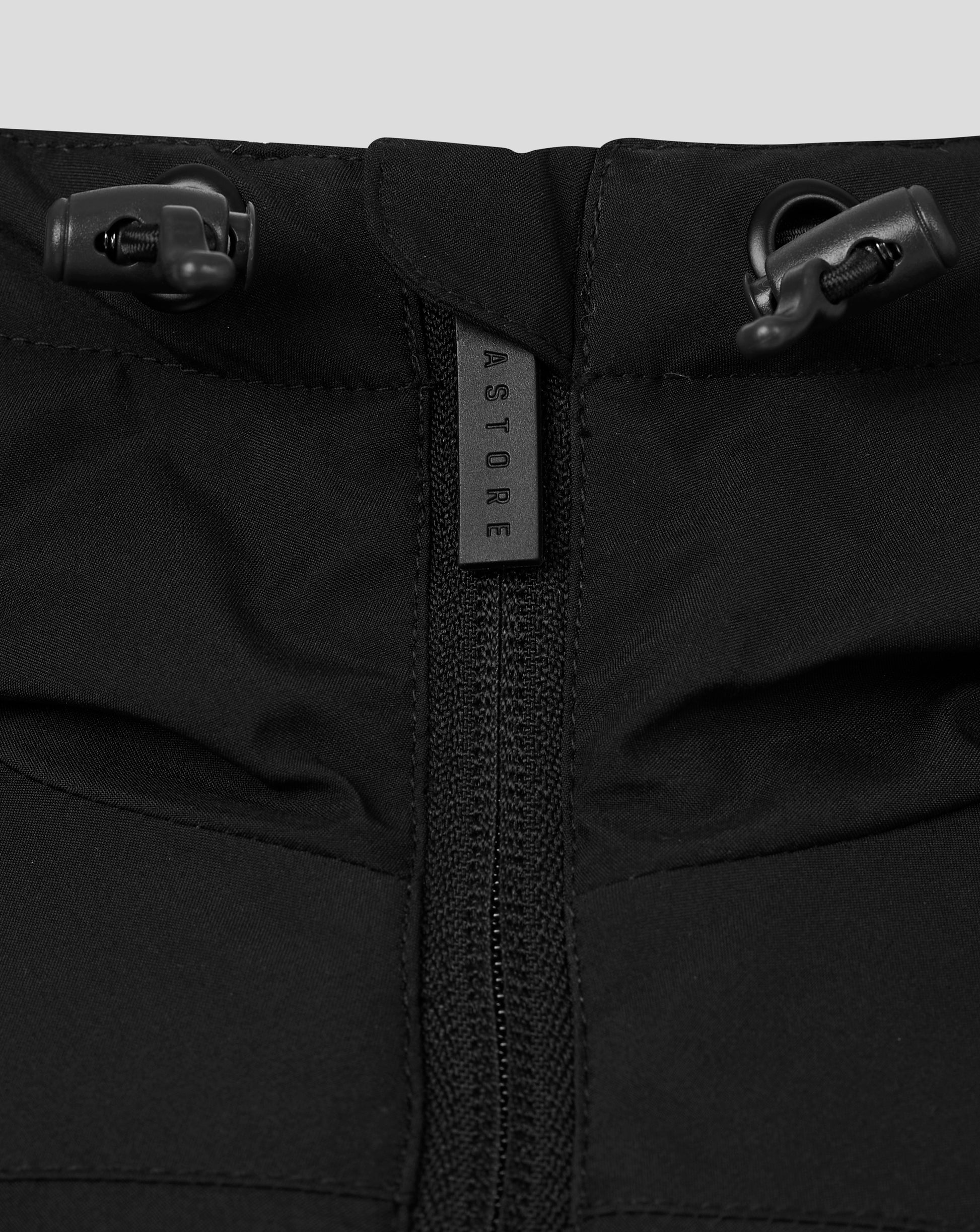 Close-up of the hood area with drawcord toggles and a branded zipper pull on the black jacket