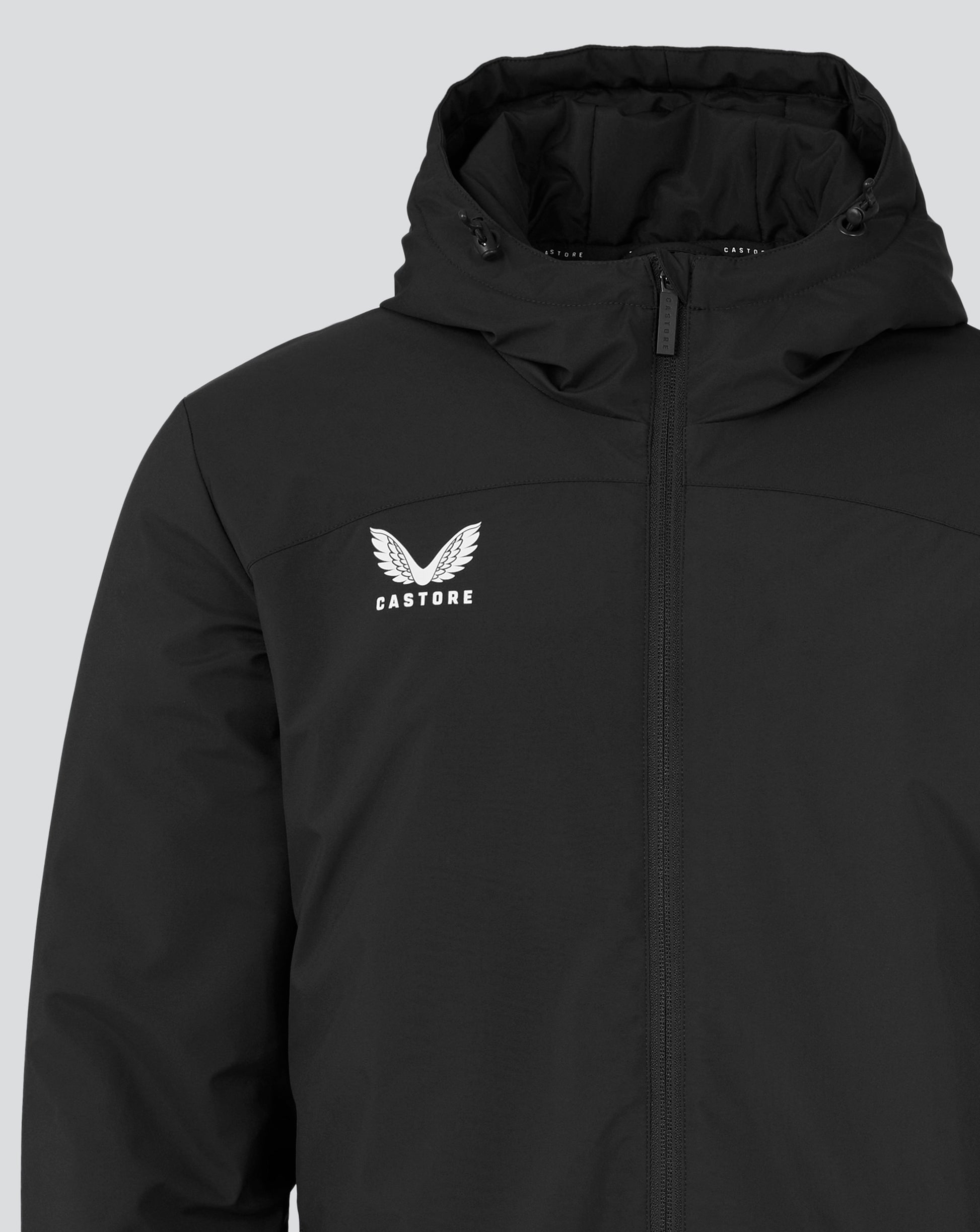 Close-up of black Mens Long Length Bench Jacket showing hood with drawcord, front zipper and Castore logo on chest.