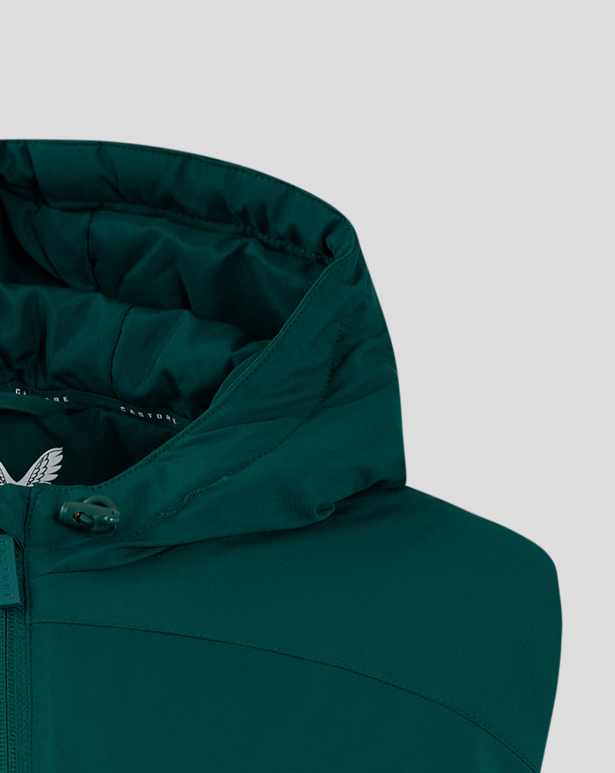 Upper front of teal padded gilet showing hood edge drawcord detail and wing logo