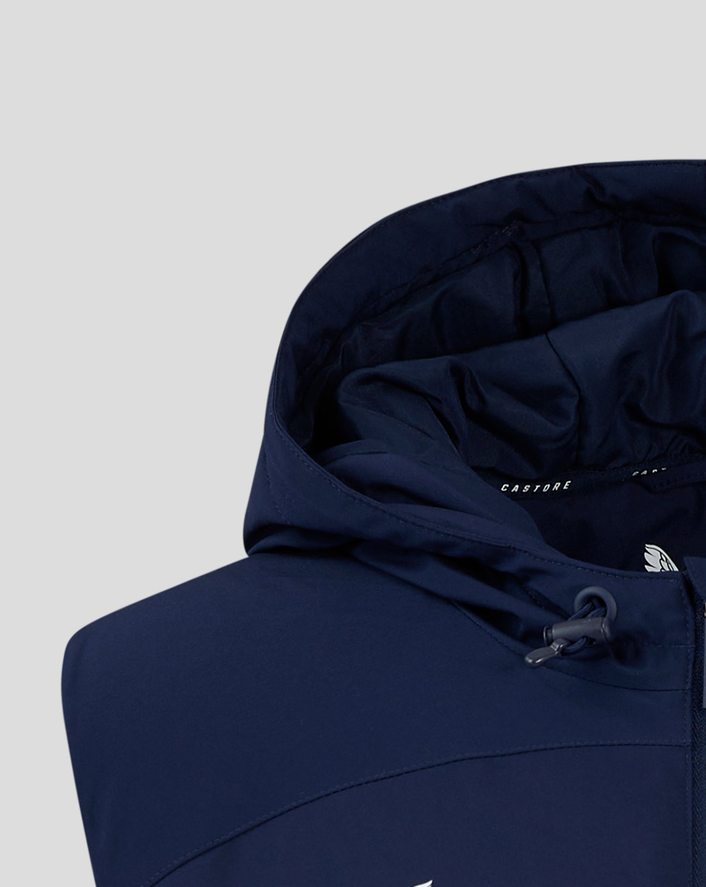 Navy padded gilet with hood; interior shows soft padding and Castore branding.