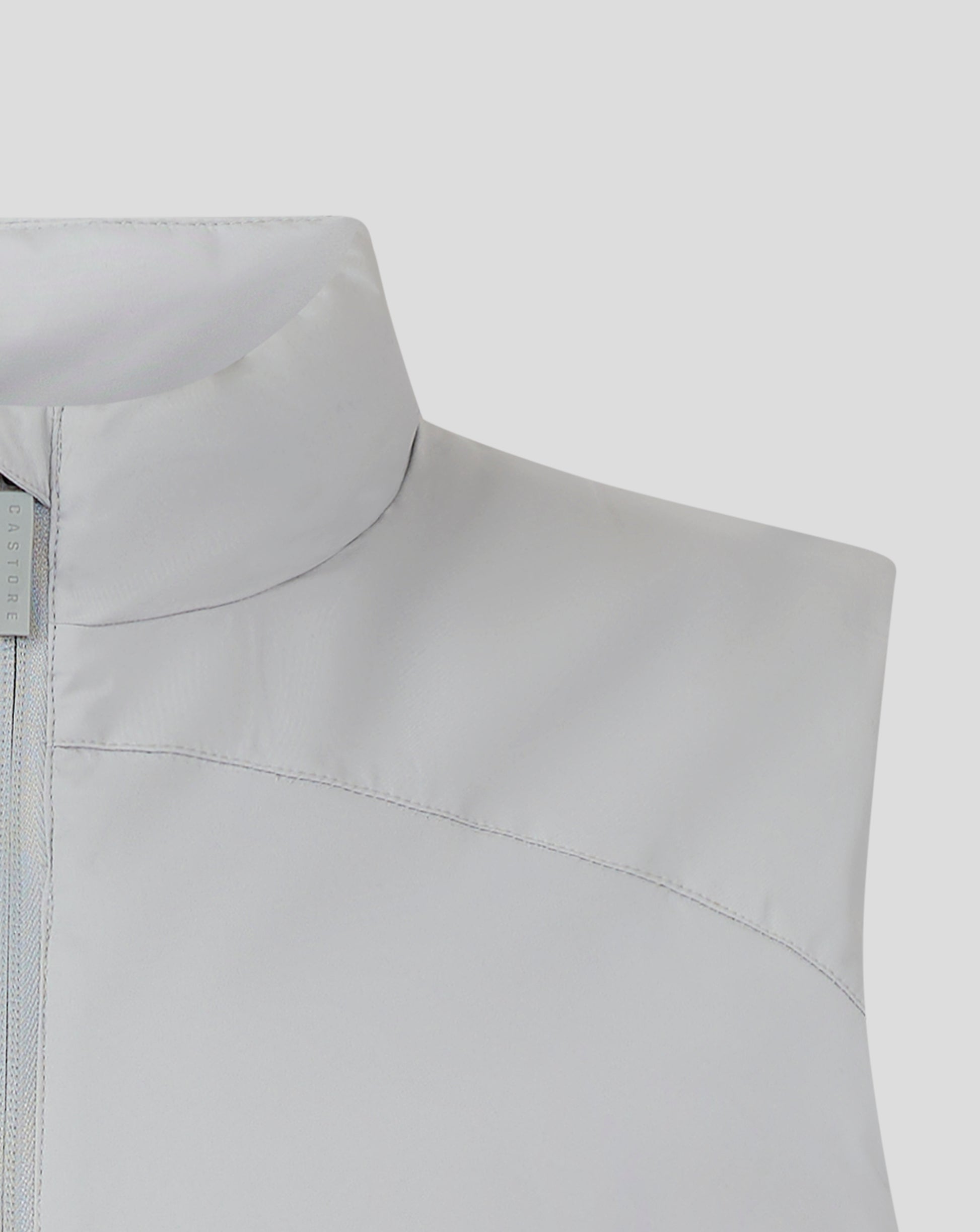 Shoulder and collar detail of light gray padded gilet with curved seams and Castore branding tag