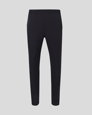 Back view of black men's track pants with an elastic waistband and tapered legs.