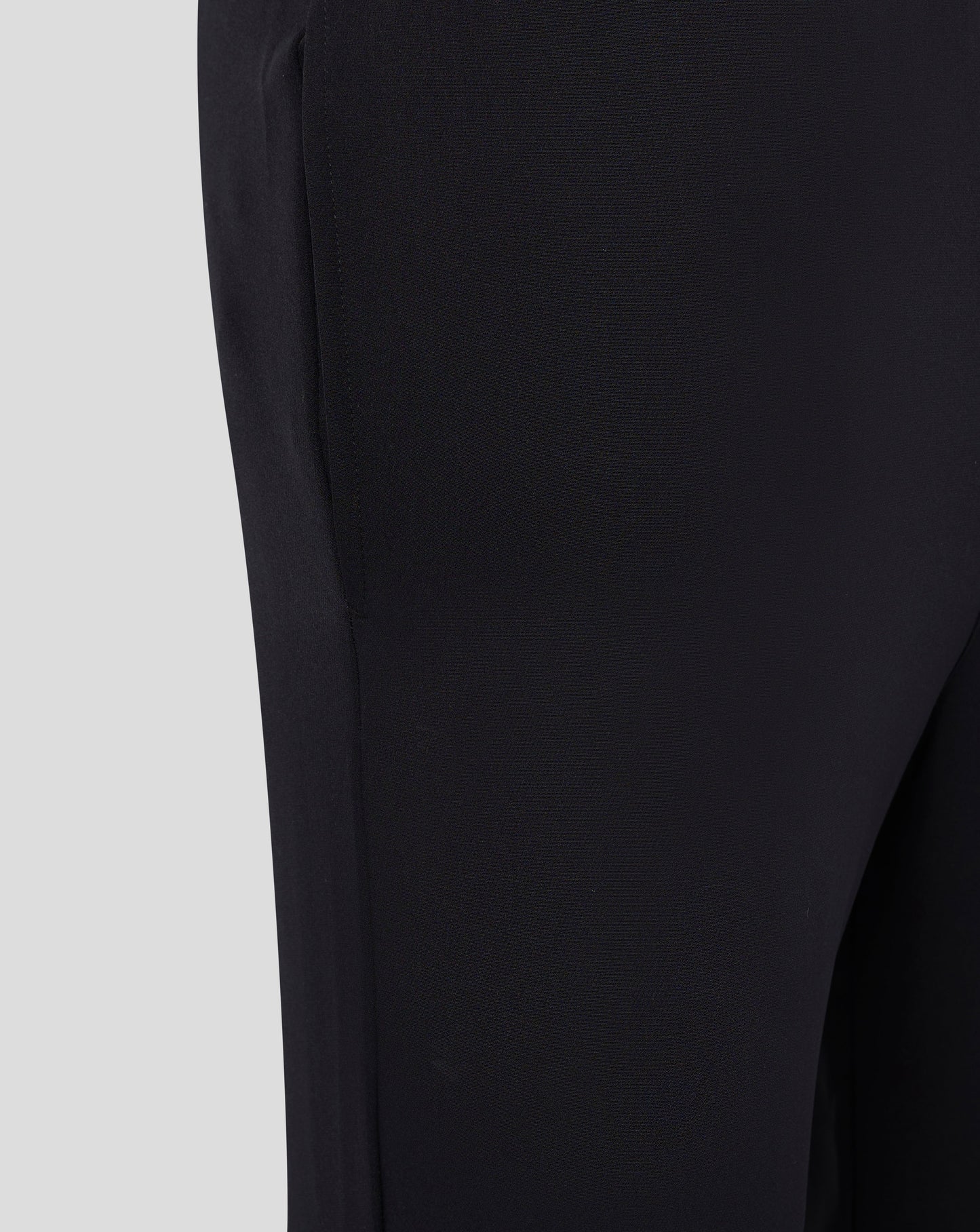 Close up of black fabric from men's track pants showing a stitched side seam