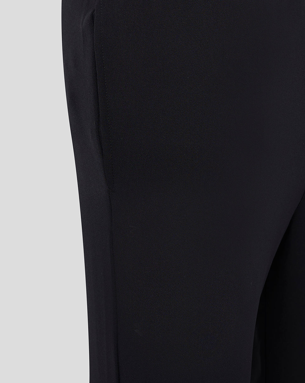 Close up of black fabric texture with ankle zipper detail on track pants.