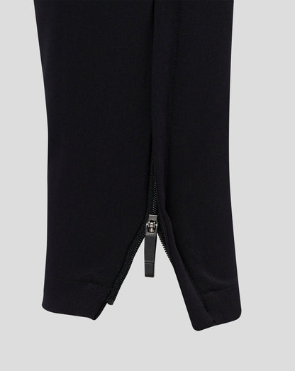 Rear view of black track pants with central seam and tapered legs