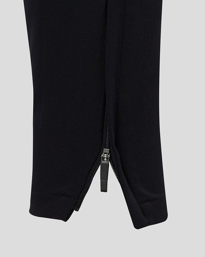 Close-up of the cuff on black men's track pants with a zipper at the ankle